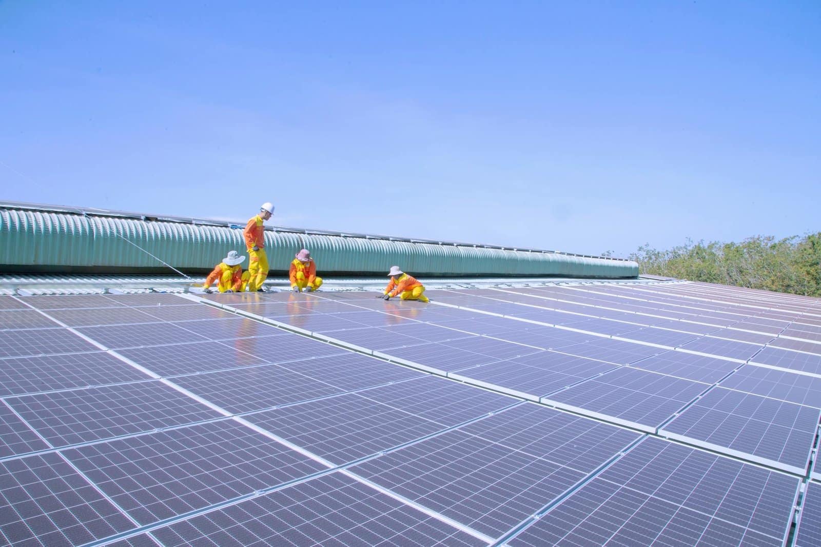 addetti ai lavori su pannelli fotovoltaici con sopra cielo azzurro