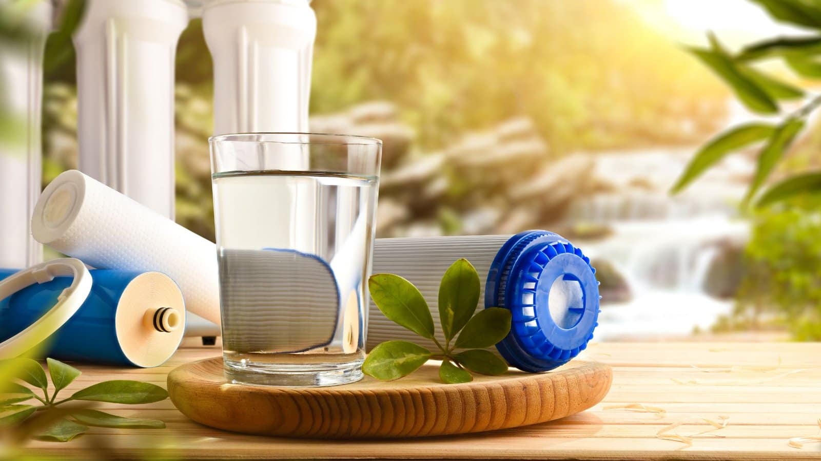bicchiere d'acqua accanto a dei filtri di depurazione