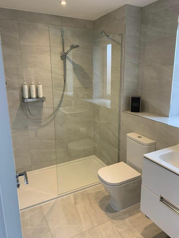 Bagno con doccia walk-in, piatto filo pavimento e rivestimento in gres chiaro