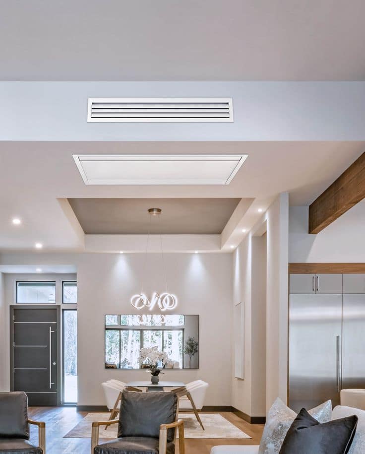 Griglie di mandata e ripresa a soffitto in un soggiorno con controsoffitto