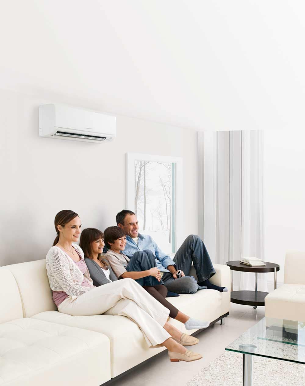 Famiglia in salotto con climatizzatore a parete