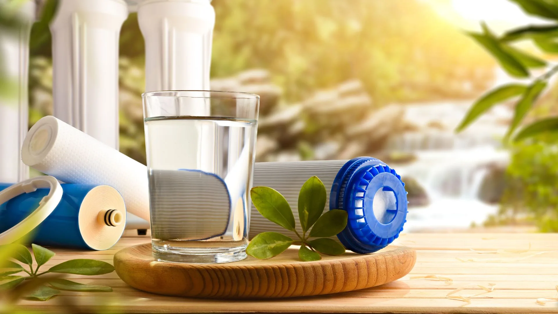 bicchiere d'acqua accanto a dei filtri di depurazione