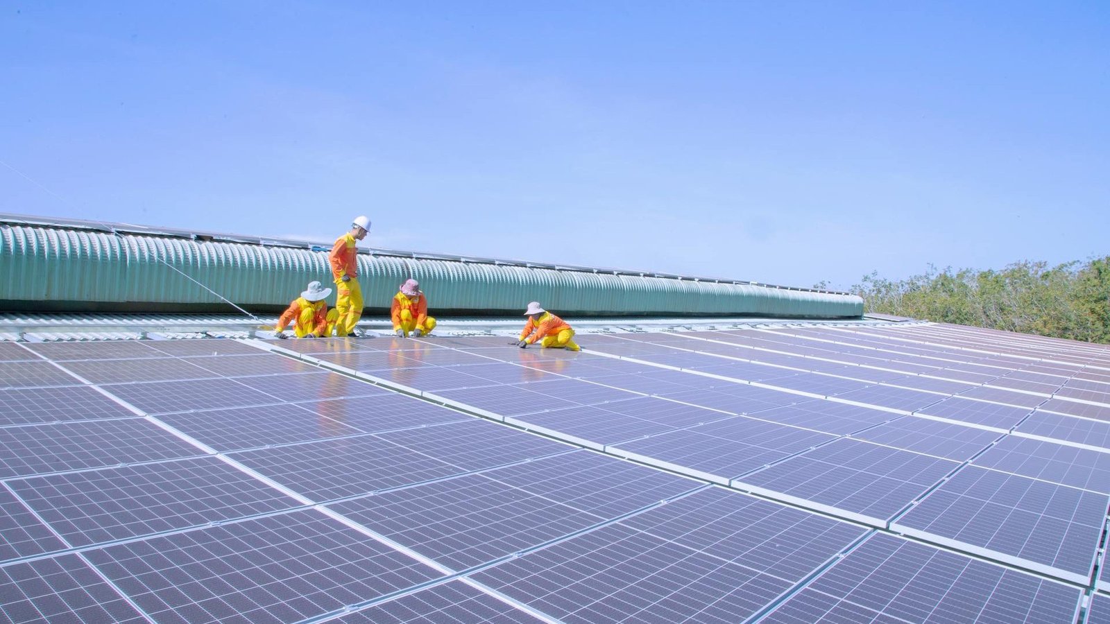 addetti ai lavori su pannelli fotovoltaici con sopra cielo azzurro